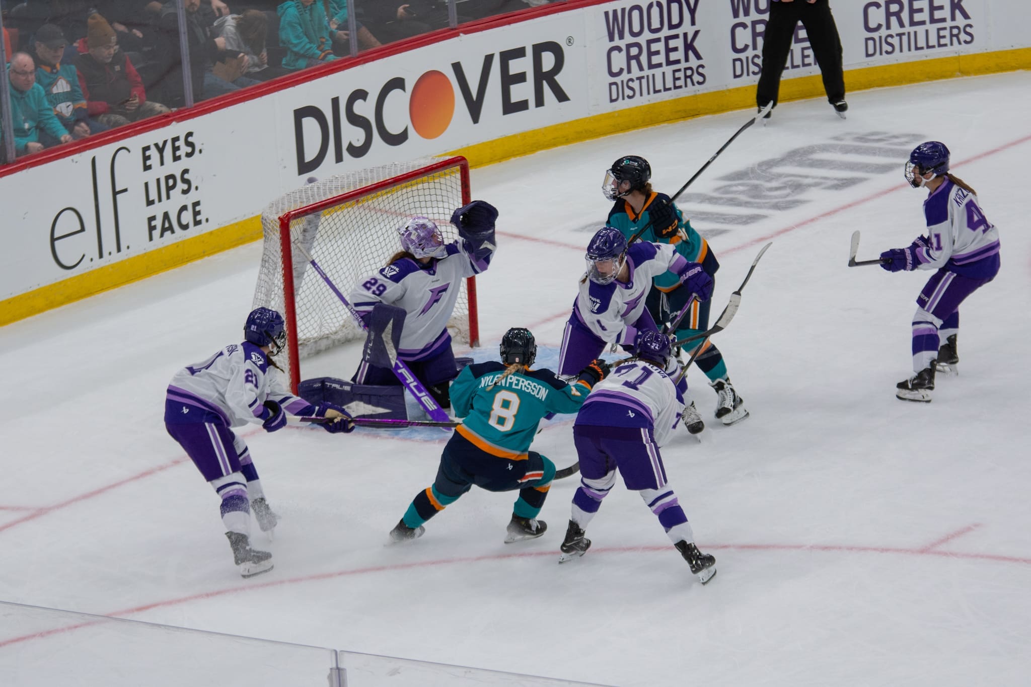 Minnesota Frost goaltender Nicole Hensley makes a crucial glove save against the New York Sirens, surrounded by teammates and opposing players in front of the net. Mandatory Credit: Bad Dawg Sports/Sebastian Zelaya