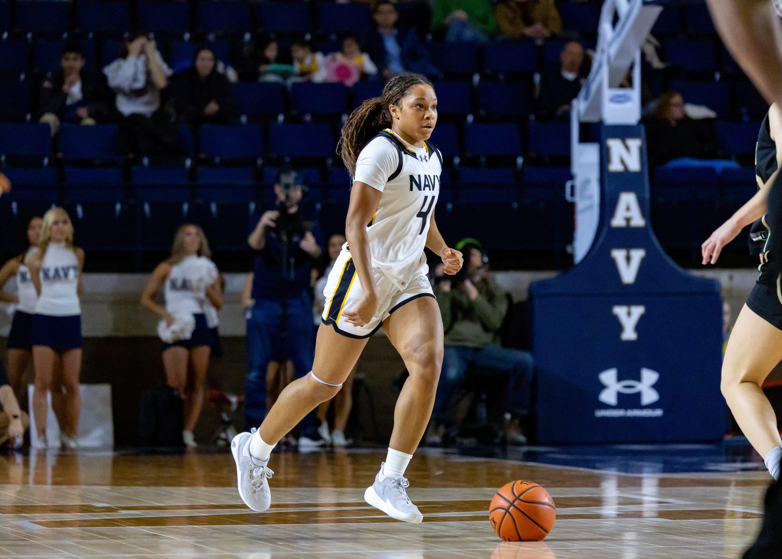 Navy guard Zanai Barnett-Gay dribbles upcourt surveying the floor during the Army–Navy women’s basketball game at Alumni Hall.
