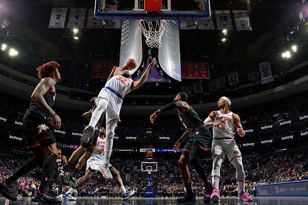 Karl-Anthony Towns rises for a rebound during Knicks–76ers action in Philadelphia.