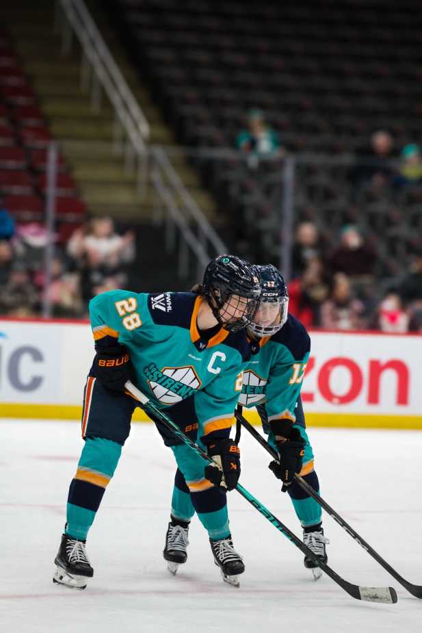 New York Sirens captain Micah Zandee-Hart (28) and teammate Taylor Girard (17) talk before a faceoff during a PWHL game.