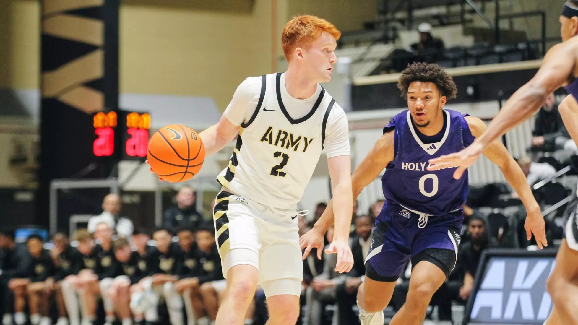 Army West Point point guard Ryan Curry dribbles on offense while defended by a Holy Cross player at Christl Arena.