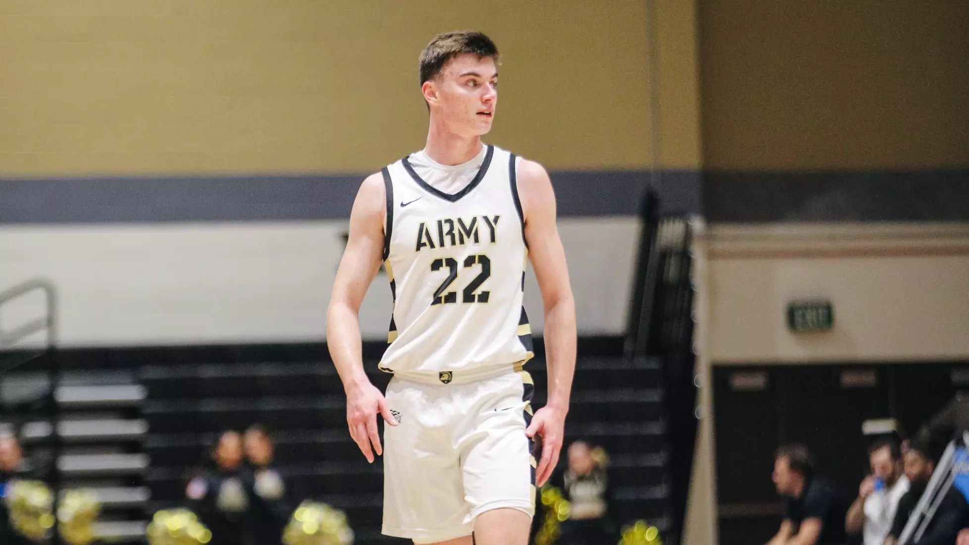 Army sophomore guard Kevin McCarthy (#22) stands on the court during a game, wearing a white Army basketball uniform.