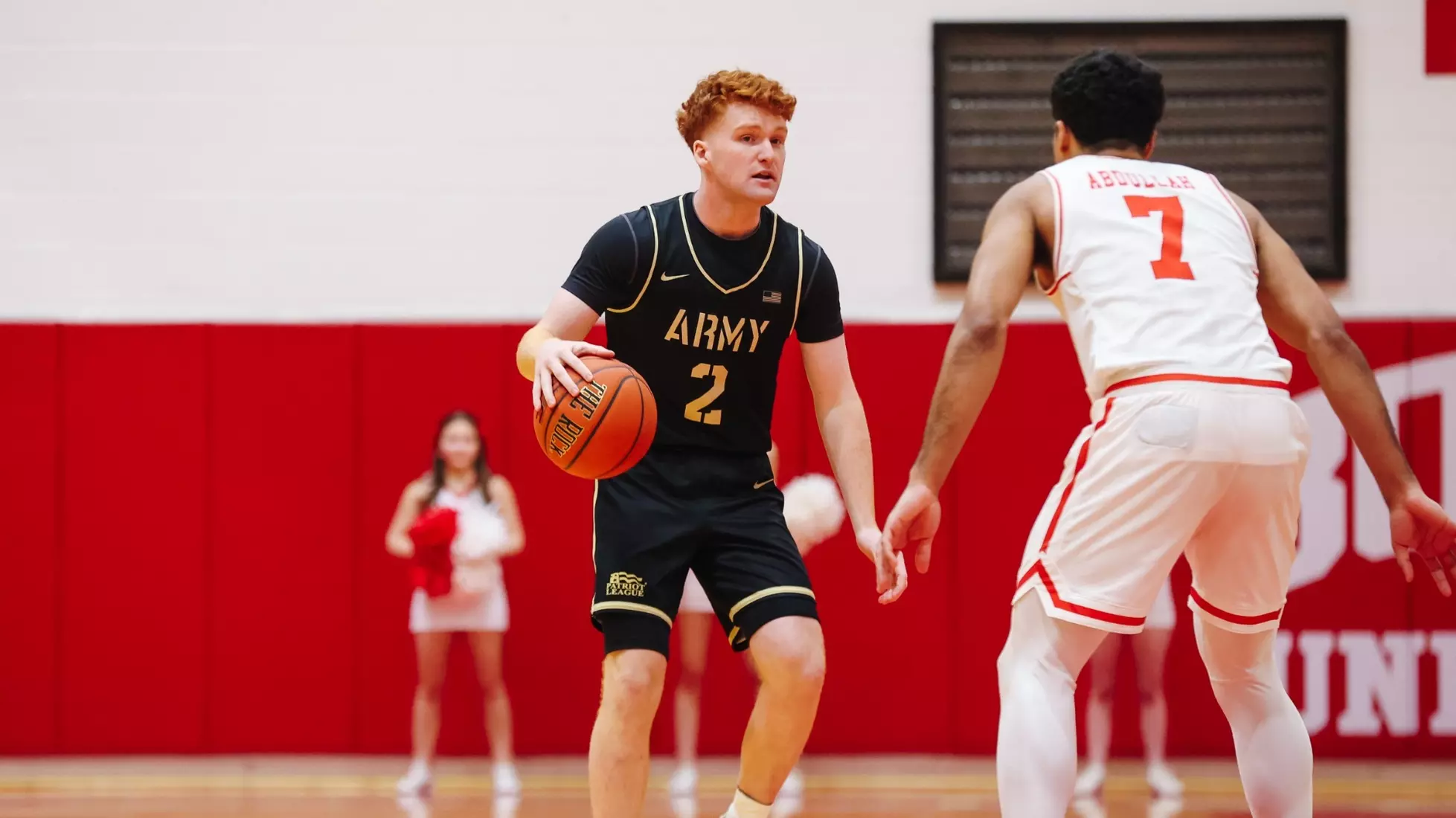 Army Black Knights guard Ryan Curry dribbling at the top of the key, guarded closely by a Boston University defender during a men’s basketball game. Mandatory Credit: Carrie Johnston/Army Athletics