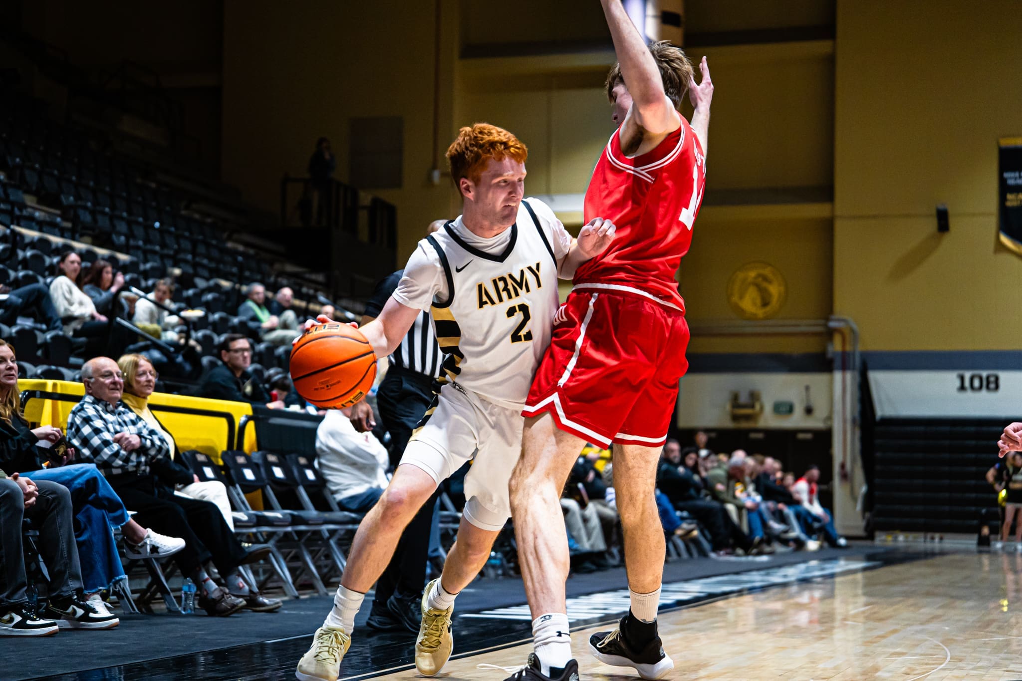 Army West Point guard Ryan Curry protects the ball along the sideline as a Boston University defender contests the dribble at Christl Arena.