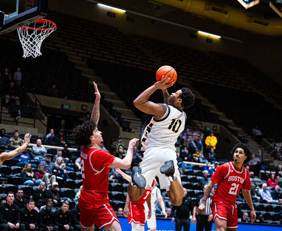 Army West Point guard Jacen Holloway rises for a twisting shot in the lane as Boston University defenders contest near the rim at Christl Arena.