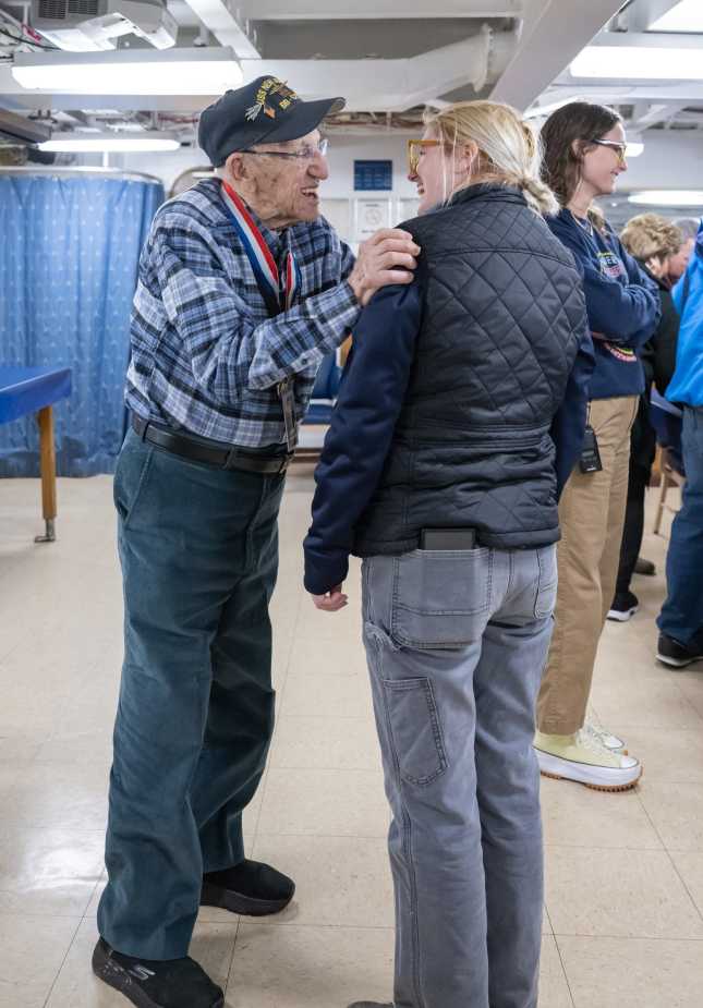 WWII Navy veteran John “Johnny Q” Quinesso Sr. greets a guest during his 100th birthday celebration aboard the Battleship New Jersey Museum in Camden, N.J.