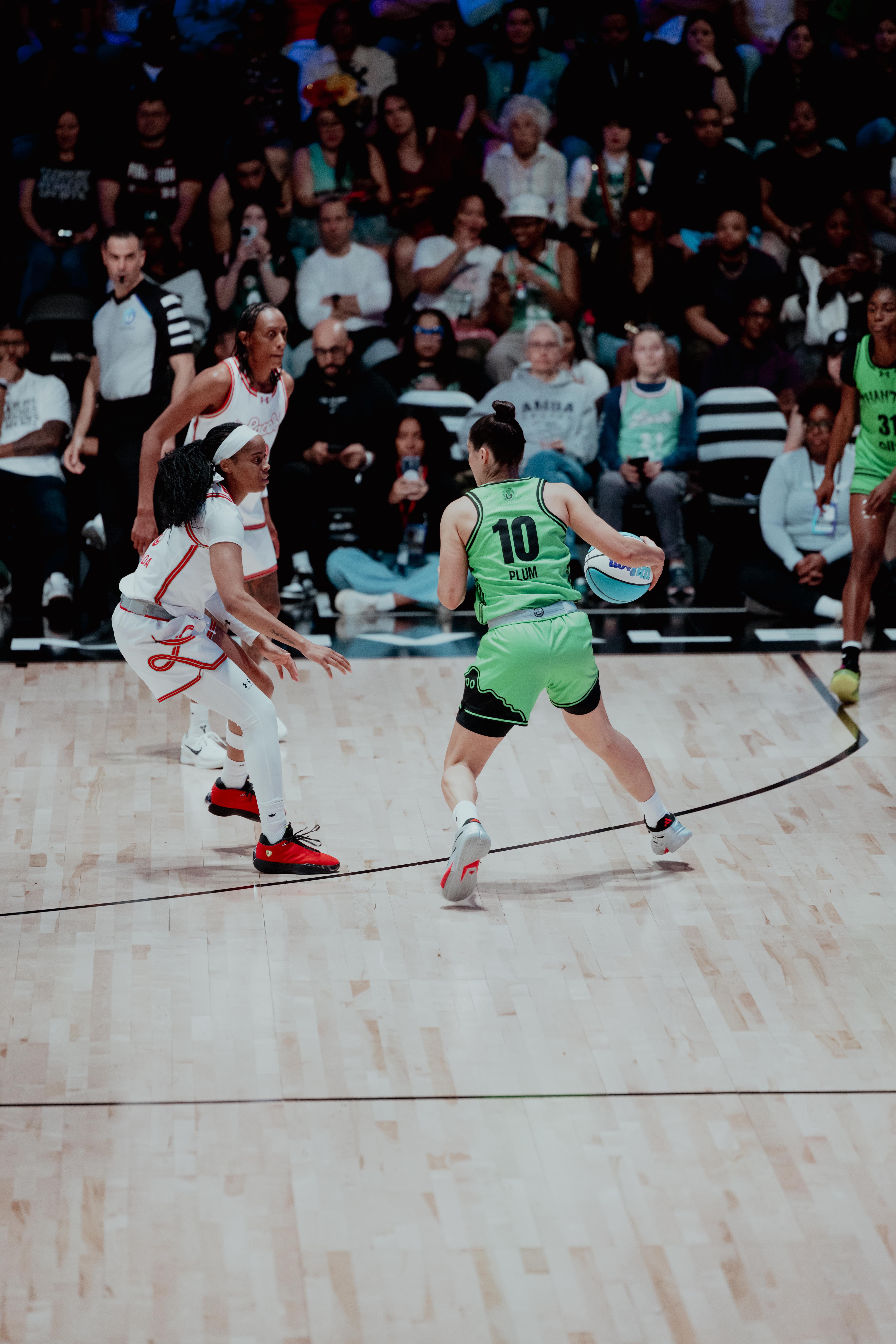 Phantom guard Kelsey Plum (10) dribbles against Laces defenders during a top-seed Unrivaled Basketball game, featuring Aliyah Boston in the background at Sephora Arena.