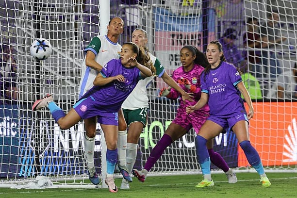 Orlando Pride’s Summer Yates challenges Denver Summit FC defenders Carson Pickett and Melissa Kössler during a goalmouth scramble at Inter&Co Stadium.