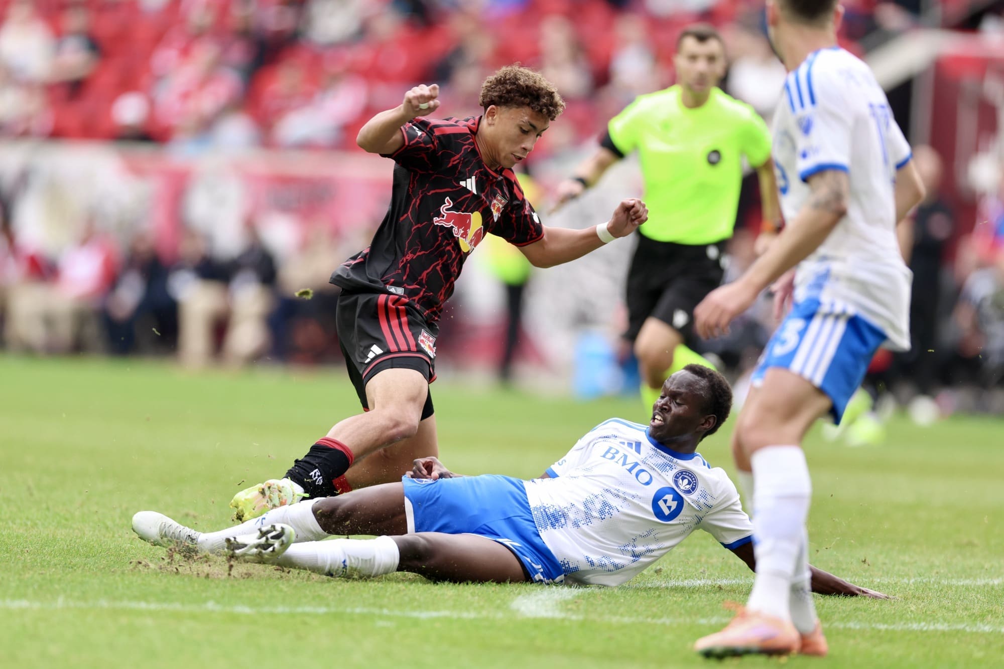 3/8/28, Harrison, New Jersey, Sports Illustrated Stadium. Julian Hall (#16) of the Red Bull New York attempts to move past CF Montréal midfielder Victor Loturi (#22) as he makes a sliding tackle during the match. Mandatory Credit: Jose Pichirilo / Bad Dawg Sports