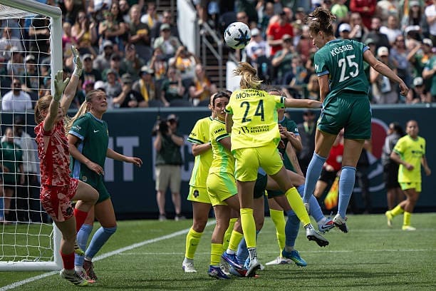 Denver Summit FC forward Melissa Kössler heads the ball toward goal as Washington Spirit goalkeeper Sandy MacIver dives to defend during the second half at Empower Field.