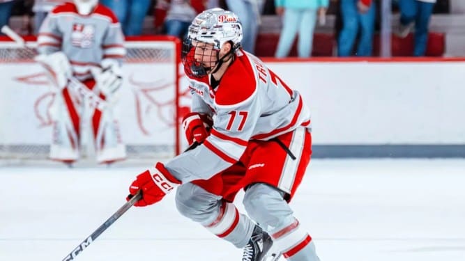Sacred Heart forward Félix Trudeau skates during game action, wearing his red-and-gray SHU uniform.