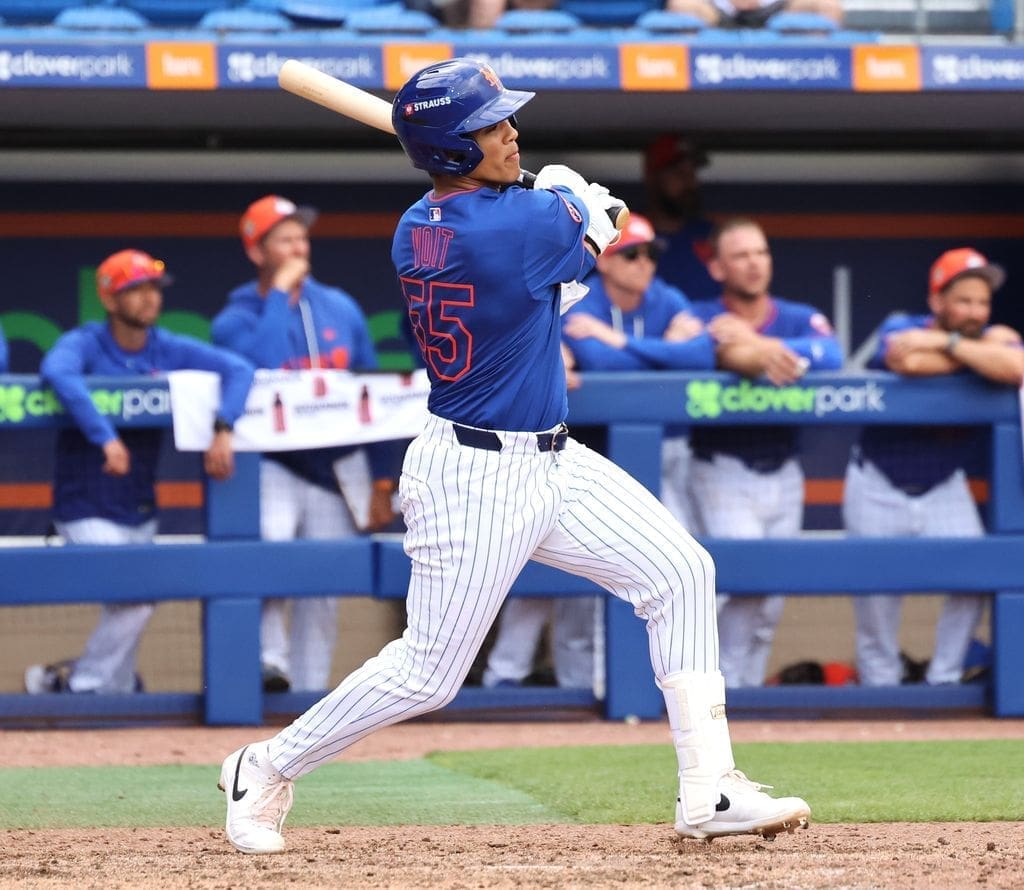 Brooklyn Cyclones infielder Mitch Voit swings during a game, captured mid‑motion with teammates watching from the dugout.