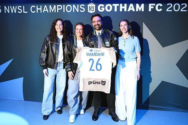 New York City Mayor Zohran Mamdani poses with Sue Bird, Ali Krieger, and Gotham FC owner Carolyn Tisch Blodgett on the sideline before the Gotham FC vs. Boston Legacy match at Sports Illustrated Stadium.